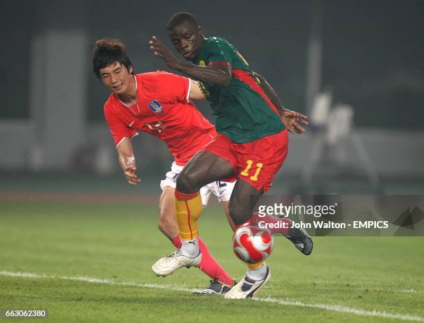 South Korea's Sung Yeung Ki and Cameroon's Gustave Bebbe battle for the ball