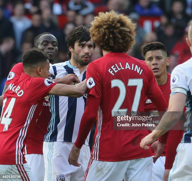 Marouane Fellaini of Manchester United clashes with Claudio Yacob of West Bromwich Albion during the Premier League match between Manchester United...
