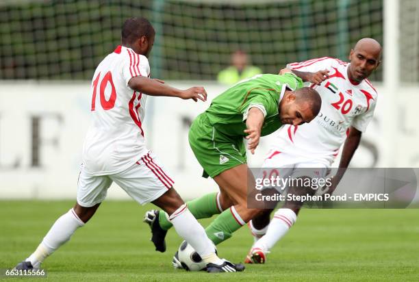 Algeria's Rafik Djebour battles for the ball with United Arab Emirates' Ismail Matar and Saeed Hilal.