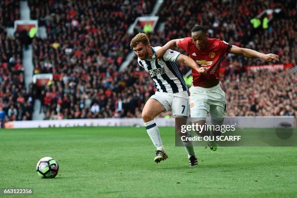 Manchester United's French striker Anthony Martial vies with West Bromwich Albion's English-born Scottish midfielder James Morrison during the...