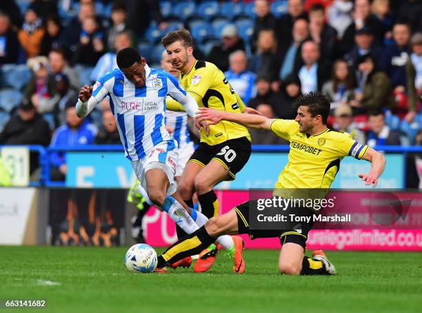 Rajiv Van La Parra of Huddersfield Town is tackled by John Mousinho of Burton Albion during the Sky Bet Championship match between Huddersfield Town...