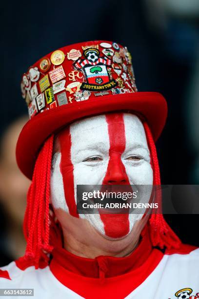 Southampton fan with a painted face laughs in the crowd ahead of the English Premier League football match between Southampton and Bournemouth at St...