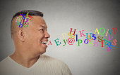 Side view portrait young handsome man talking with alphabet letters coming out of open mouth