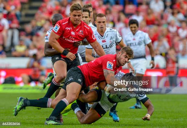 Malcolm Marxs of the Lions tackles Lukganyo Am of the Sharks during the Super Rugby match between Emirates Lions and Cell C Sharks at Emirates...