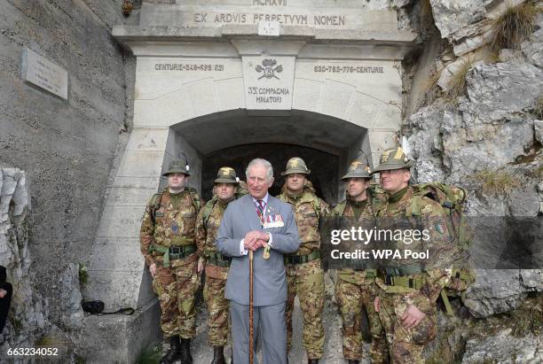 Prince Charles, Prince of Wales with soldiers from Italy's Alpini mountain warfare military corps at the entrance to a tunnel high in the Dolomite...