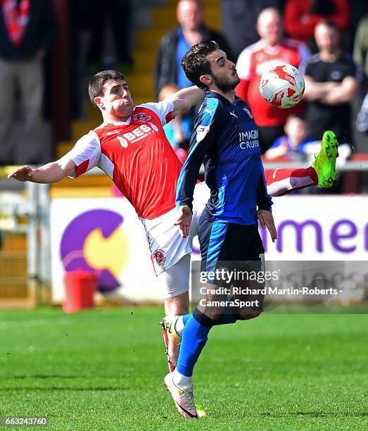 Swindon Town's John Goddard competes with Fleetwood Town's Bobby Grant during the Sky Bet League One match between Fleetwood Town and Swindon Town at...