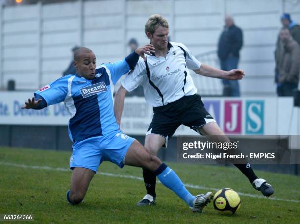 Eastwood Town's Andy Todd is tackled by Wycombe Wanderers' Leon Johnson.