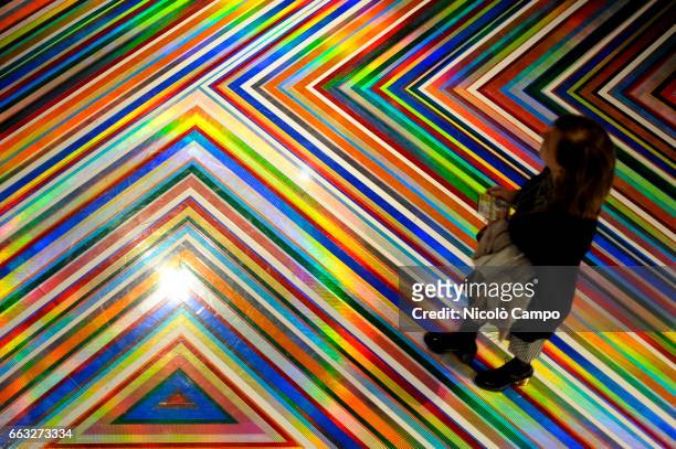 Visitor walks over an art installation by Scottish artist James 'Jim' Lambie entitled 'Zobop' during the art exhibition 'L'emozione dei COLORI...