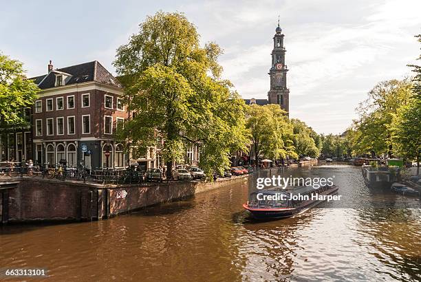 tour boat on canal in amsterdam, netherlands - turistbåt bildbanksfoton och bilder