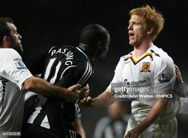 Newcastle United's Sebastien Bassong is pulled away from Hull City's Paul McShane by Hull City's Ian Ashbee.