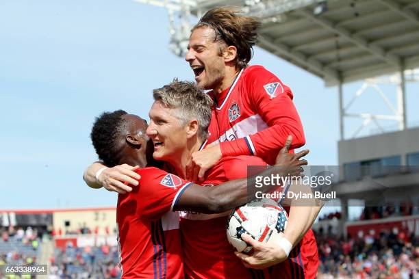 Bastian Schweinsteiger of Chicago Fire is congratulated by David Accam and Joao Meira after scoring a goal in the first half against the Montreal...