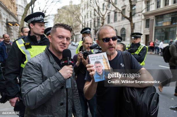 Tommy Robinson, former leader of the English Defence League with a fan holding his book 'Enemy of the State' as supporters of far-right and...