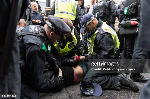 Police officers arrest protester during a counter-demonstration to oppose far-right Britain First and the English Defence League protests in central...
