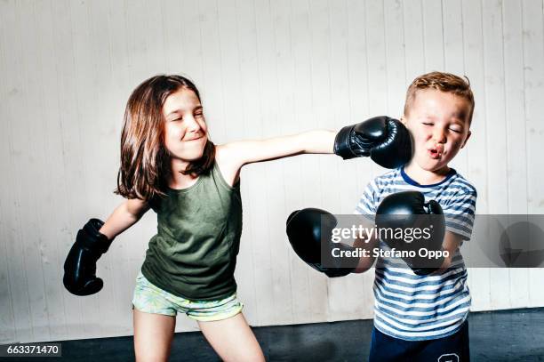 little girl and boy boxing - sfondo bianco stock pictures, royalty-free photos & images