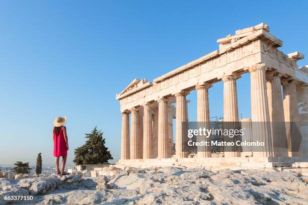 woman in front of parthenon temple on the acropolis, athens, greece - acropolis foto e immagini stock