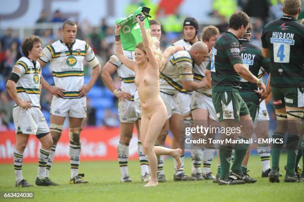 Female streaker runs infront of the Northampton Saints' players during the game