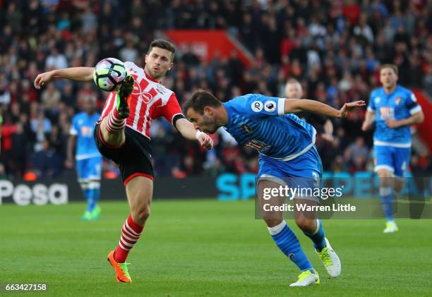 Shane Long of Southampton is tackled by Steve Cook of AFC Bournemouth during the Premier League match between Southampton and AFC Bournemouth at St...