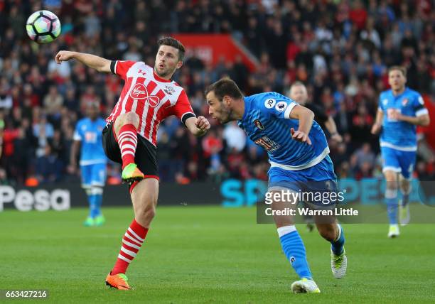 Shane Long of Southampton is tackled by Steve Cook of AFC Bournemouth during the Premier League match between Southampton and AFC Bournemouth at St...