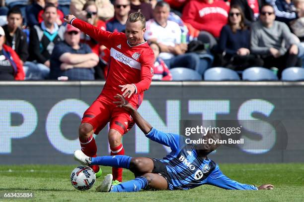 Hassoun Camara of Montreal Impact tackles the ball from Michael Harrington of Chicago Fire in the second half during an MLS match at Toyota Park on...