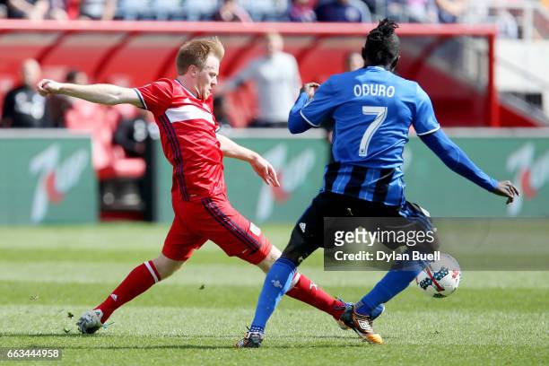 Dax McCarty of Chicago Fire passes the ball while being defended by Dominic Oduro of Montreal Impact in the second half during an MLS match at Toyota...