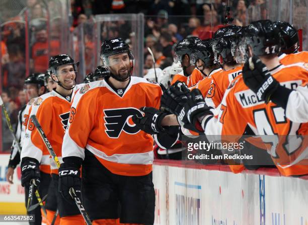 Colin McDonald of the Philadelphia Flyers celebrates his first period goal against the New Jersey Devils with his teammates on the bench on April 1,...