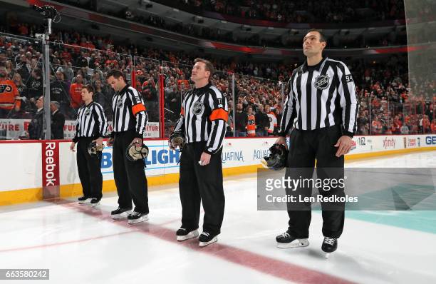 Officials Devin Berg, Francois St. Laurent, Kelly Sutherland and Bryan Pancich stand at center ice for the National Anthem prior to a NHL game...