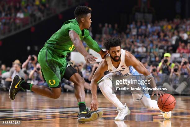 Joel Berry II of the North Carolina Tar Heels dribbles the ball as Dylan Ennis of the Oregon Ducks runs up to him during the 2017 NCAA Photos via...