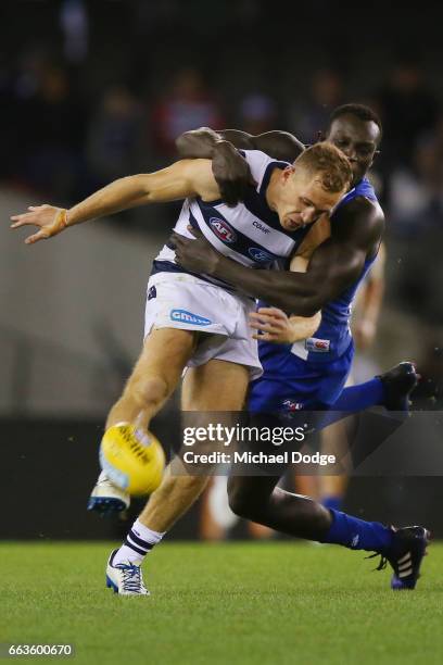 Joel Selwood of the Cats is tackled by Majak Daw of the Kangaroos during the round two AFL match between the Geelong Cats and the North Melbourne...