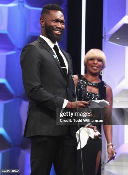 Screenwriter Tarell Alvin McCraney accepts award for 'Moonlight' from singer Mary J. Blige onstage during the 28th Annual GLAAD Media Awards in LA at...