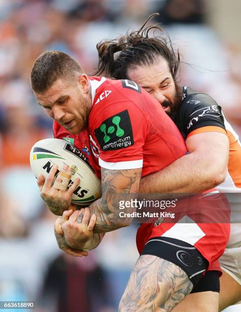 Josh Dugan of the Dragons is tackled by Aaron Woods of the Tigers during the round five NRL match between the Wests Tigers and the St George...