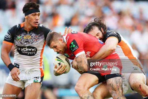 Josh Dugan of the Dragons is tackled by Aaron Woods of the Tigers during the round five NRL match between the Wests Tigers and the St George...