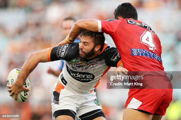 James Tedesco of the Tigers offloads the ball in a tackle during the round five NRL match between the Wests Tigers and the St George Illawarra...