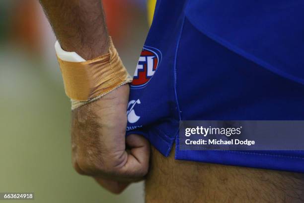 Lindsay Thomas of the Kangaroos grabs his shorts before kicking for goal during the round two AFL match between the Geelong Cats and the North...