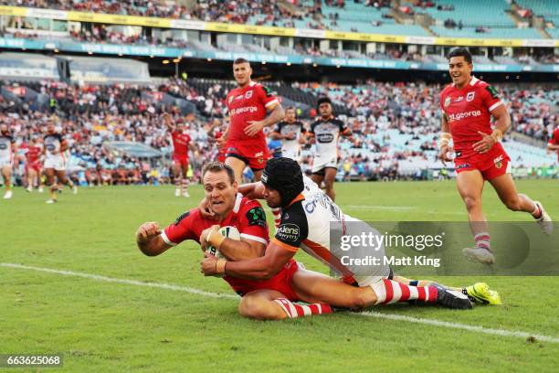 Jason Nightingale of the Dragons beats David Nofoaluma of the Tigers to score a try during the round five NRL match between the Wests Tigers and the...