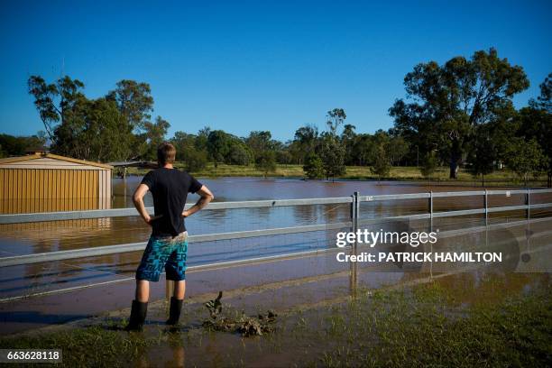 Daniel Jones watches as floodwaters caused by Cyclone Debbie recede in the town of Beenleigh on April 2, 2017. Rising floods continued to plague...