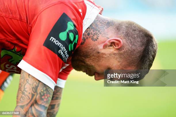 Josh Dugan of the Dragons looks dejected after sustaining an injury during the round five NRL match between the Wests Tigers and the St George...