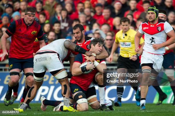 Jack O'Donoghue of Munster by Yoann Maestri and Joe Tekori of Toulouse during the European Rugby Champions Cup Quarter-Final match between Munster...