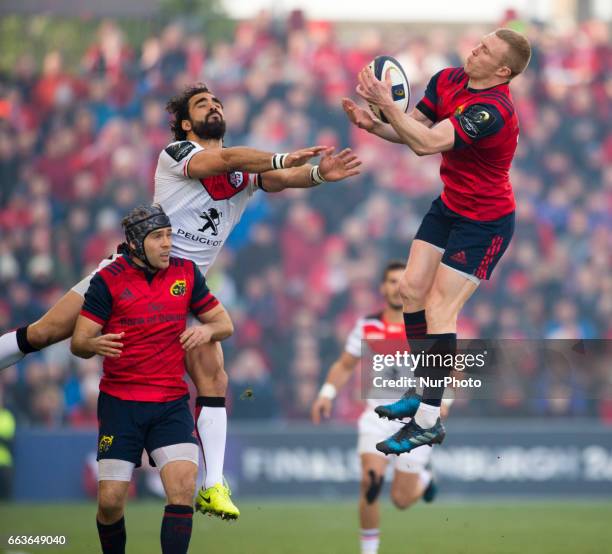 Keith Earls of Munster jumps high for the ball with Yoann Huget of Toulouse during the European Rugby Champions Cup Quarter-Final match between...