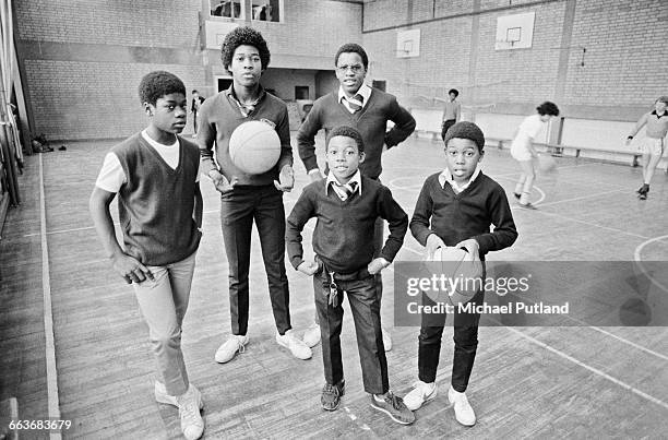 British reggae group Musical Youth on a basketball court at their school, Duddeston Manor School, Birmingham, UK, 1982. Left to right: bassist...