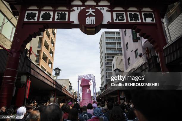 People carry a large phallus-like statue during the annual Kanamara Festival in Kawasaki on April 2, 2017. Japanese revellers carried giant phalluses...