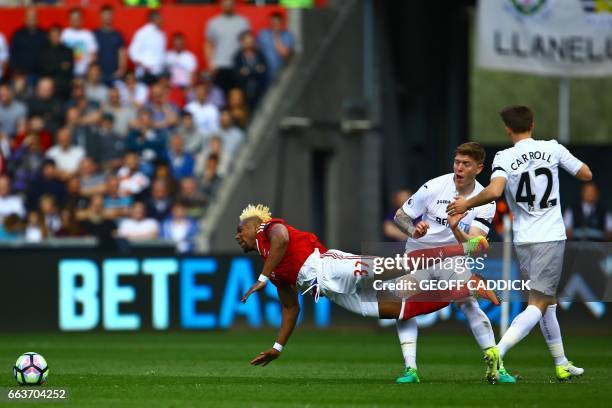 Middlesbrough's Spanish midfielder Adama Traore falls under a challenge from Swansea City's English defender Alfie Mawson during the English Premier...