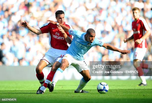 Manchester City's Nigel De Jong and Arsenal's Robin van Persie battle for the ball
