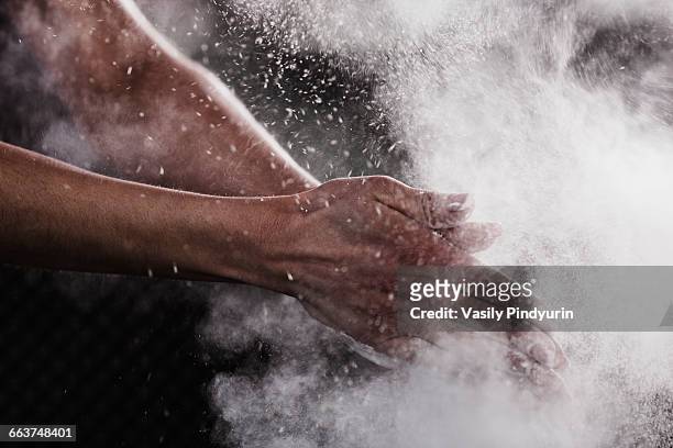 cropped image of womans hand dusting chalk powder for exercising - hard talk stockfoto's en -beelden