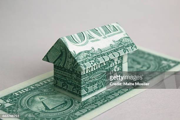 house made of one dollar us notes against white background - finance and economy photos stock illustrations