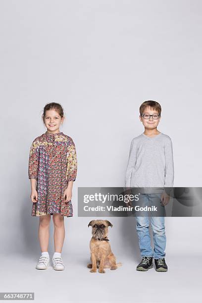 portrait of siblings with dog against white background - fashion family stock-fotos und bilder