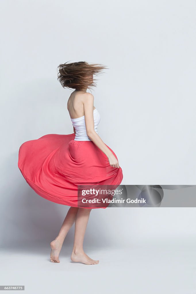 Young woman spinning against white background