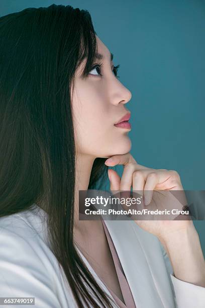 woman daydreaming with hand under chin - mano-en-la-barbilla fotografías e imágenes de stock