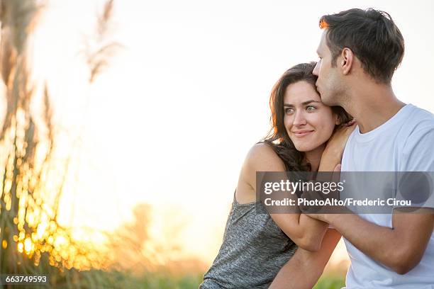 man kissing girlfriends forehead - head on shoulder stock pictures, royalty-free photos & images