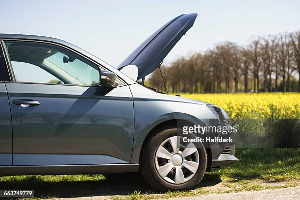cropped image of broken down car on roadside - cofano foto e immagini stock