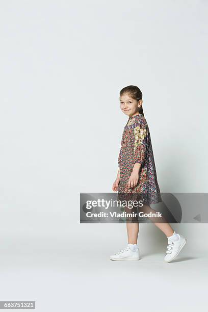 portrait of smiling girl walking against white background - bambini camminano foto e immagini stock